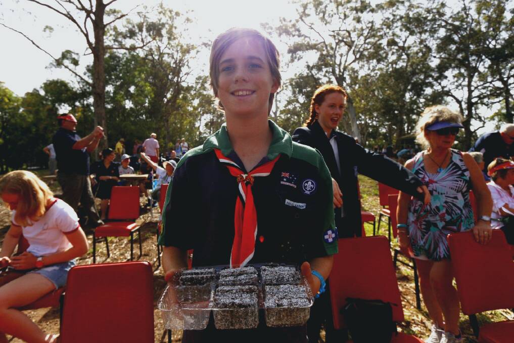 Scout Patrol leader Edward Peterson hands out lamingtons to the crowd at the Merimbula Rotary Club  Australia day event. Photo Rachel Mounsey