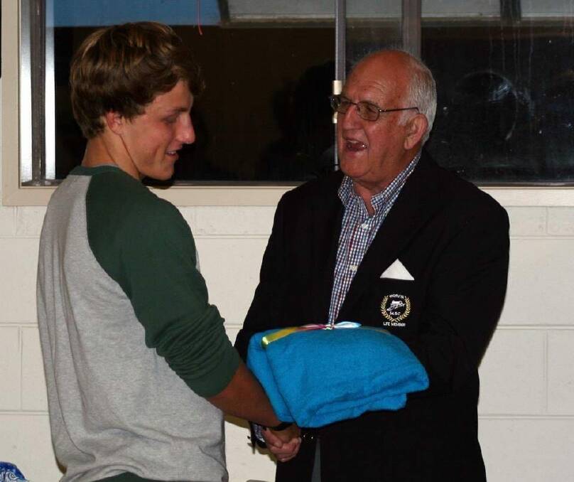 Max Hogno presenting an award to a young lifesaver of Moruya Surf Life Saving Club. 