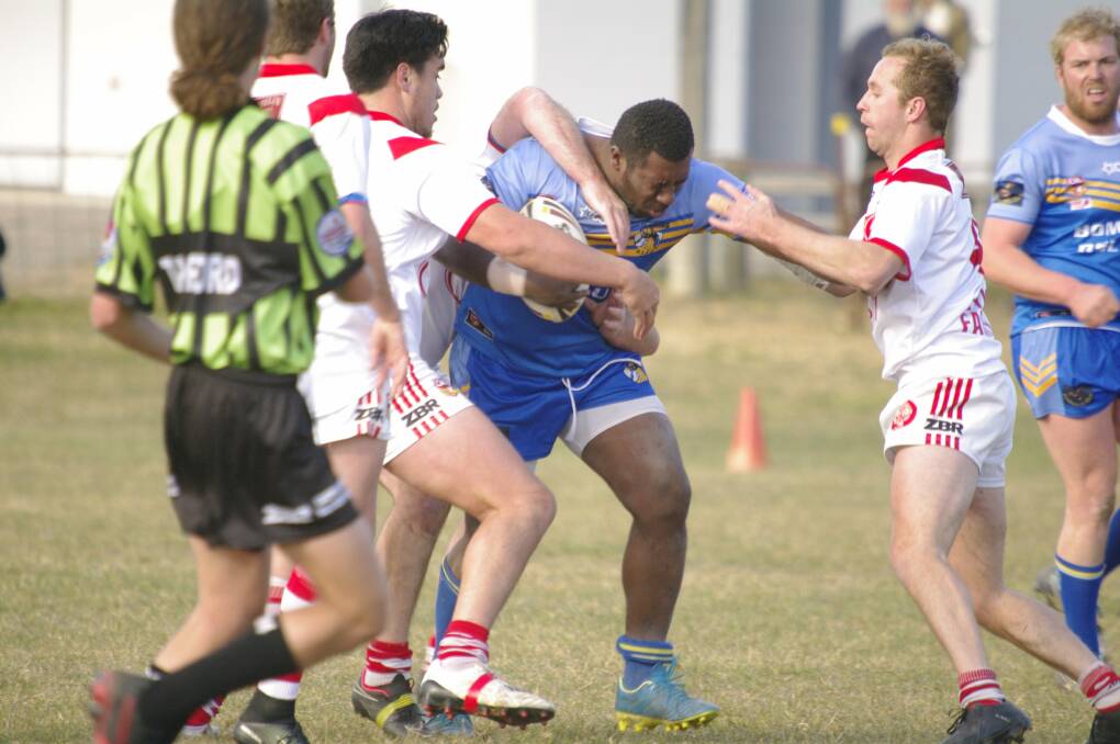 Bombala's Saimoni Buinimasi fends off a hoard of Eden players during Saturday's rugby league game at the Bombala Showground.