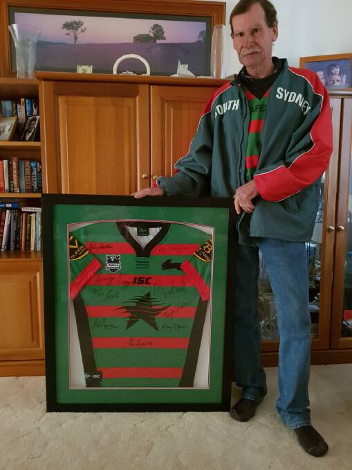 Bombala Golf Club president, Brendan Weston with the framed South Sydney jumper signed by the 1971 grand final players that will be auctioned through pickles.com.au.