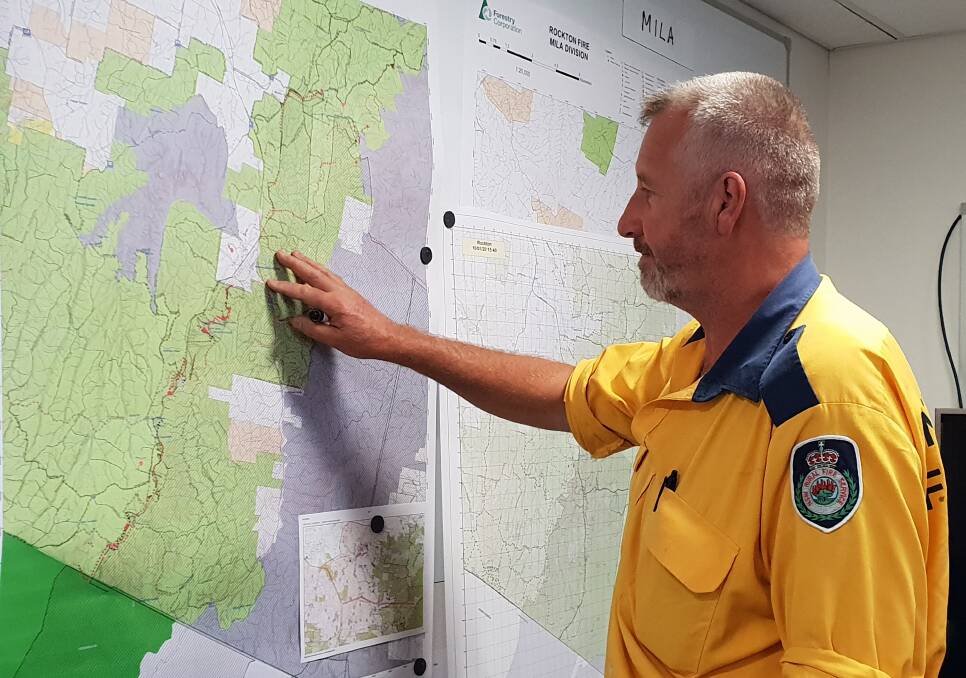 NSW RFS Learning and Development Officer, Tim Ingram from the Monaro Rural Fire Station studies a map of the fires at the Bombala Fire Control Centre in Bombala.