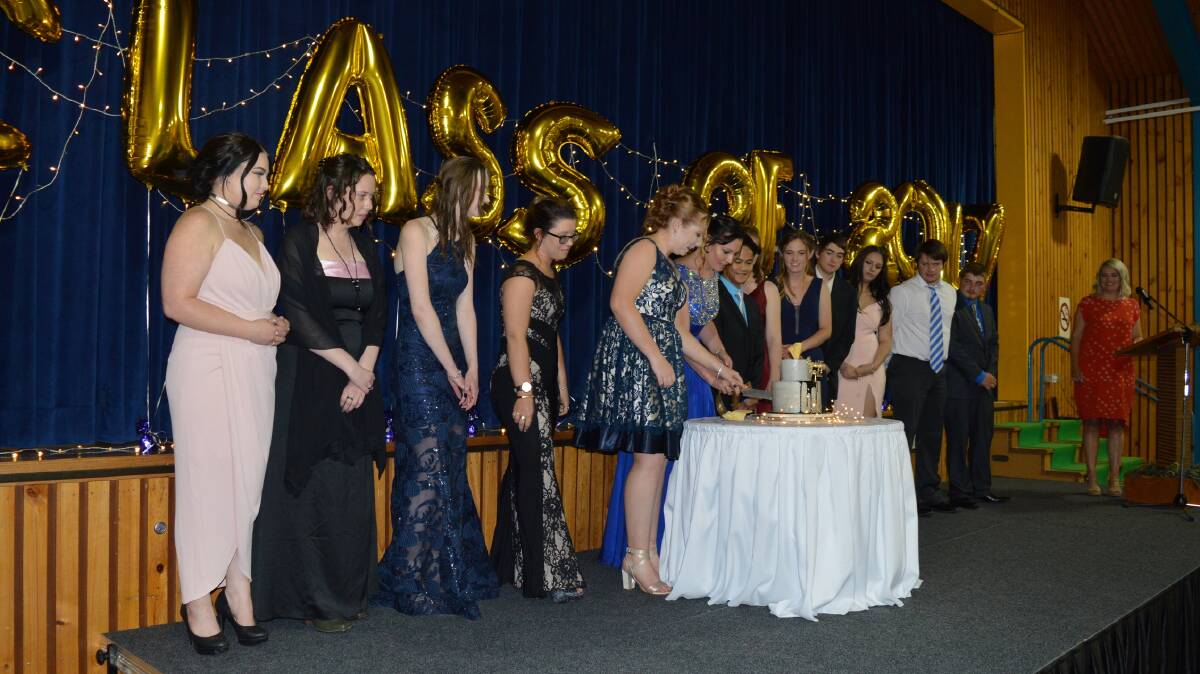 GOOD LUCK: Bombala High School Higher School Certificate students cut their cake at the school formal in the Bombala School Hall.