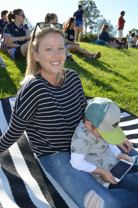 Keyara Marshell of Cooma with a very distracted Tyler Jones at the football in Moruya on Sunday.