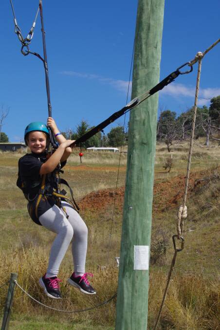 SWINGING HIGH: Year five Bombala Public School student, Maeya Olding hangs on the rope swing at Cooba Sports and Education Centre at Berridale.