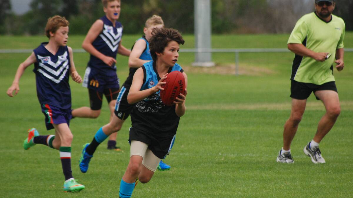 BATEMANS BAY: Under 14s player Zane Rowley looks up the wing against the Ulladulla Dockers on Sunday. 