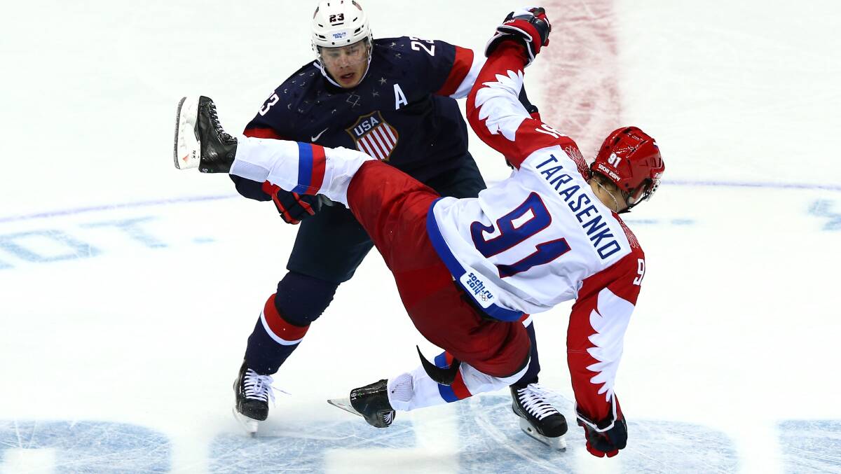 Dustin Brown #23 of the United States collides wih Vladimir Tarasenko #91 of Russia during the Men's Ice Hockey Preliminary Round Group A game on day eight of the Sochi 2014 Winter Olympics at Bolshoy Ice Dome. Photo by Clive Mason/Getty Images