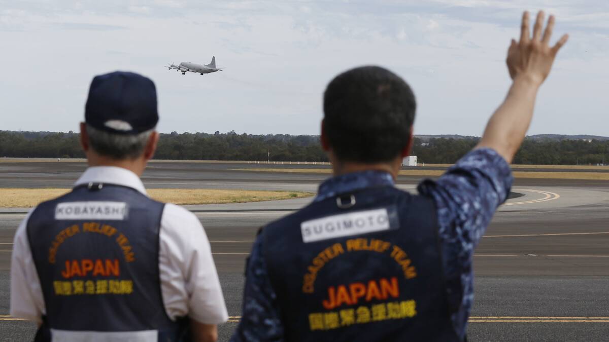 embers of Japan's disaster relief team wave off a Japan Maritime Self-Defence Force Lockheed P-3C Orion aircraft as it takes off from the RAAF base Pearce to commence a search for possible debris from the Malaysian Airlines flight MH370 on March 24. Picture: Getty