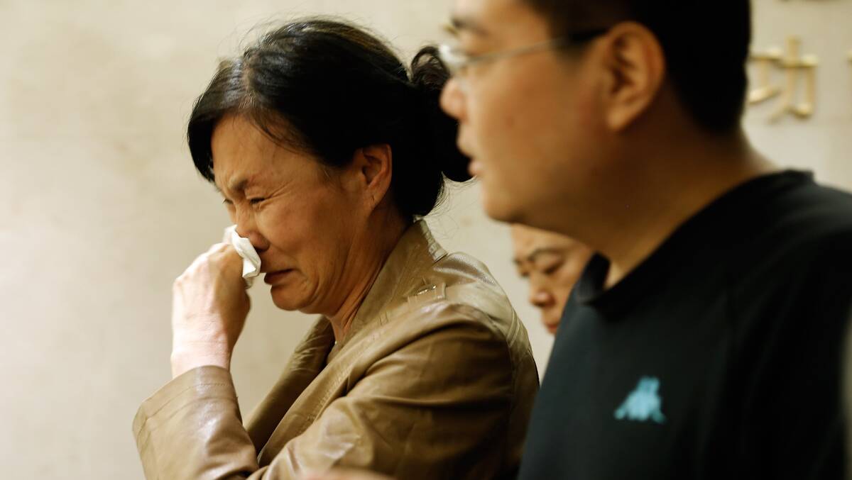 A family member of a passenger from the missing Malaysia Airlines flight MH370 shows her emotion at Lido Hotel on March 24, 2014 in Beijing, China as French authorities reported a satellite sighting of objects in the southern Indian Ocean where China and Australia also reported sighting potential debris from missing flight MH370. Picture: Getty