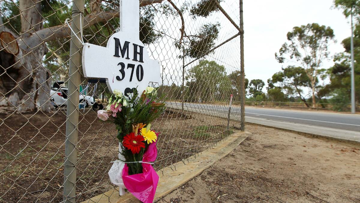 Flowers and a memorial for the missing passengers of flight MH370 are attached to the perimeter fence of RAAF Pearce Airbase on March 26, 2014 in Bullsbrook, 35km north of Perth, Australia. Picture: Getty