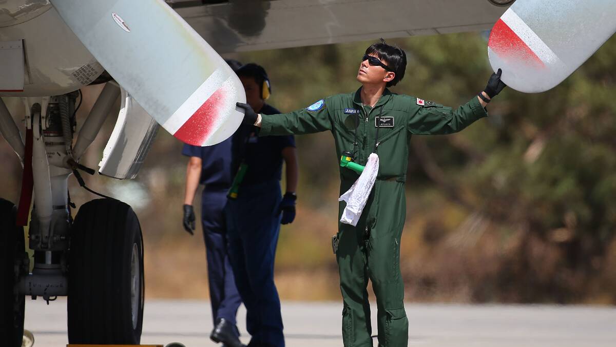  A Japanese Maritime Self Defence Force member inspects a P-3 Orion prior to departure from the RAAF base Pearce to commence a search for possible debris on March 24. Picture: Getty