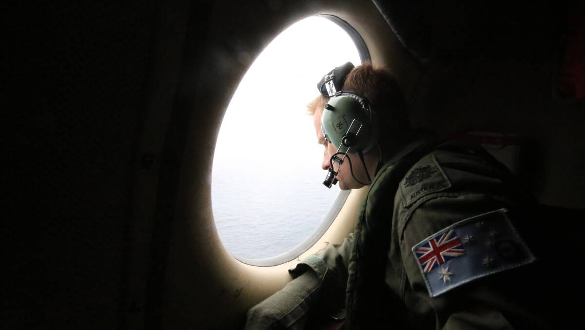 Aircrew look out of a window of a Royal Australian Air Force AP-3C Orion from RAAF base Pearce on assignment to Southern Indian Ocean. Picture: Getty