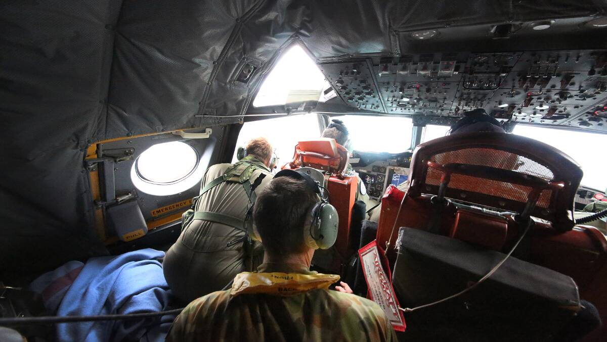 Aircrew look out of a window of a Royal Australian Air Force AP-3C Orion from RAAF base Pearce on assignment to Southern Indian Ocean as the search for the missing Malaysian airliner begins off the coast of Perth.
