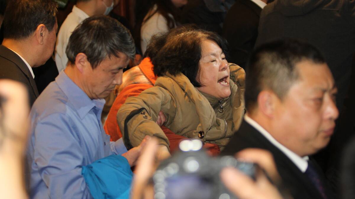 A family member of a passenger from the missing Malaysia Airlines flight MH370 reacts at Lido Hotel on March 24, 2014 in Beijing, China, following Malaysian Prime Minister Najib Razak's announcement that a fresh analysis of satellite data concluded the missing flight MH370's final position was in the southern Indian Ocean.