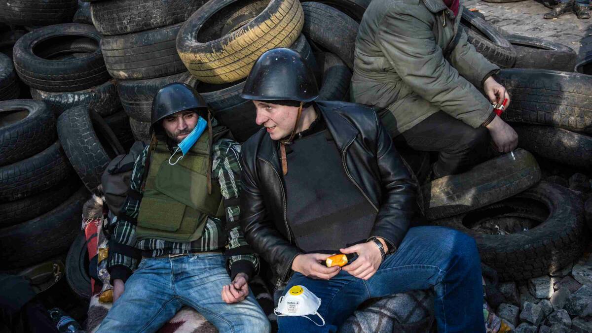 Anti-government protesters relax by barricades made of tires in Independence Square in Kiev. Picture: Getty Images
