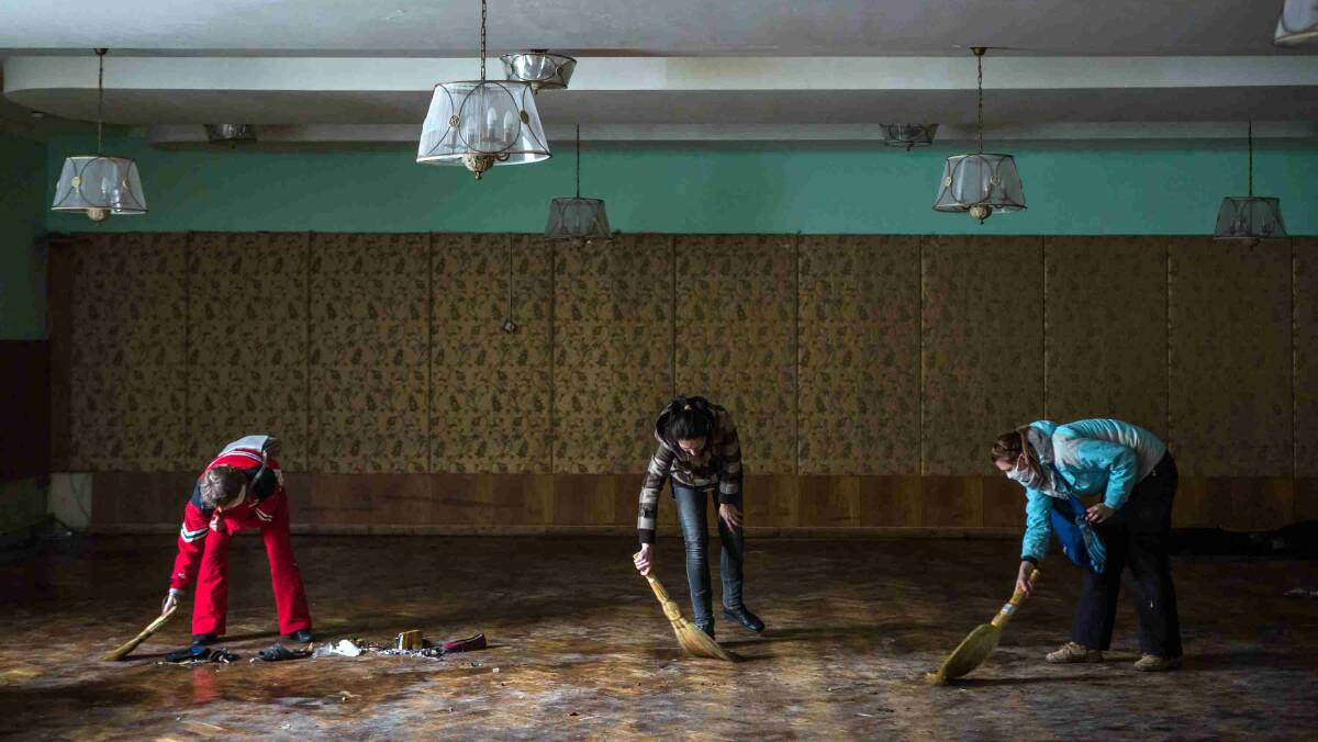 Women clean inside the partially burned Trade Unions Building, which has served as a de facto headquarters for anti-government protesters on Independence Square in Kiev. Picture: Getty Images