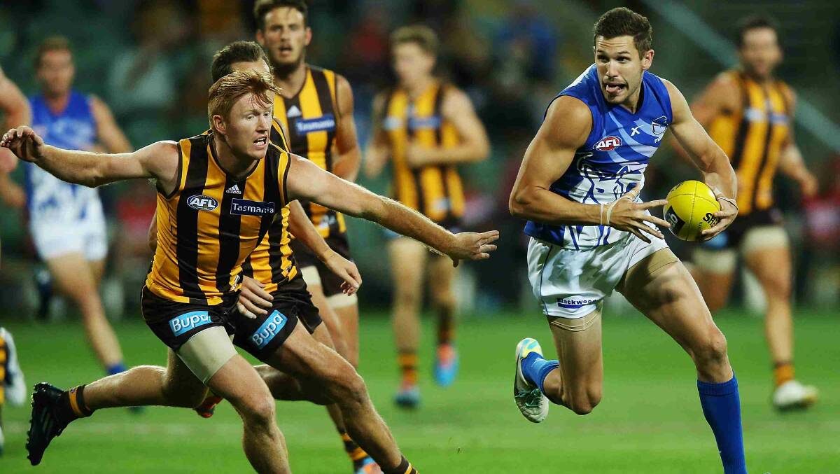 Aaron Black of the Kangaroos runs with the ball away from Kyle Cheney of the Hawks during the round two AFL NAB Challenge match between the Hawthorn Hawks and the North Melbourne Kangaroos at Aurora Stadium. Picture: Getty Images