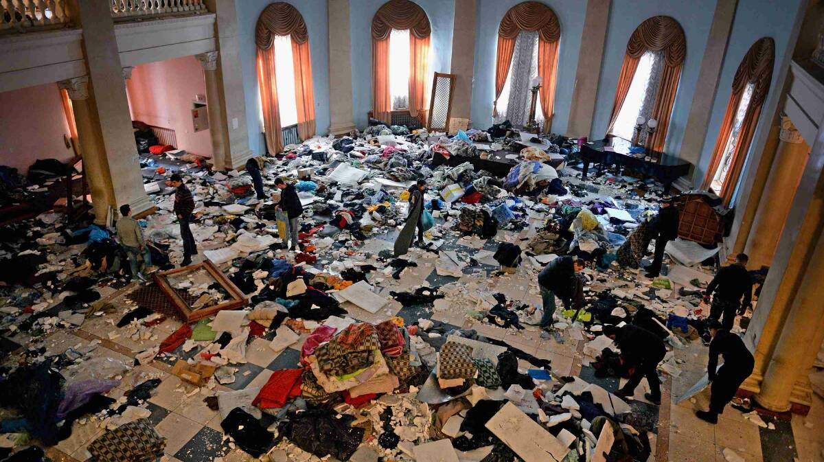People search through debris inside the International Centre of Culture and Arts as Anti- Government demonstrators continue to occupy Independence square in Kiev. Picture: Getty Images