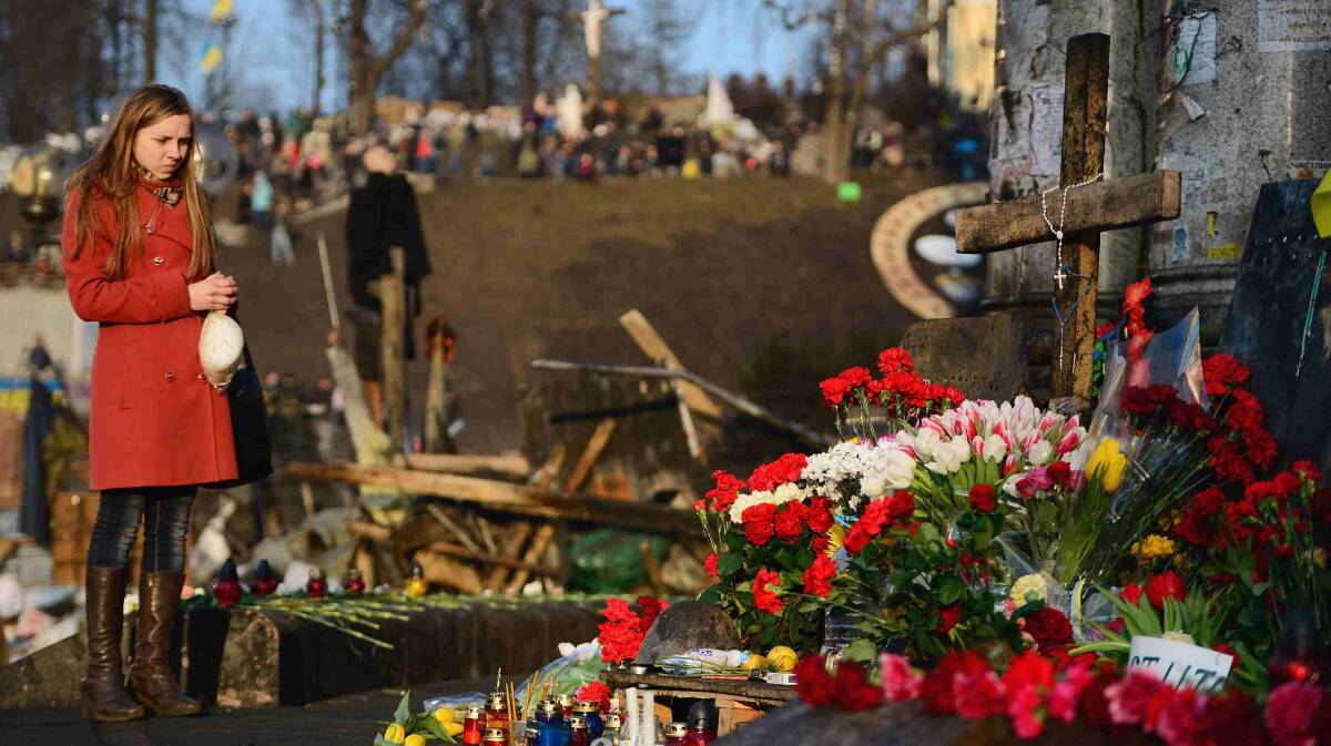  A woman reacts at a makeshift shrine to the anti-government demonstrators killed in clashes with police in Independence Square in Kiev. Picture: Getty Images