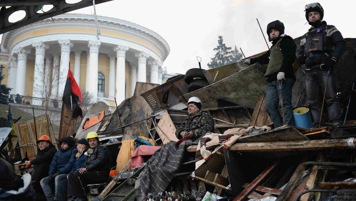 Anti-government protesters man the front line barricades following clashes with police in Independence square in Kiev. Picture: Getty Images