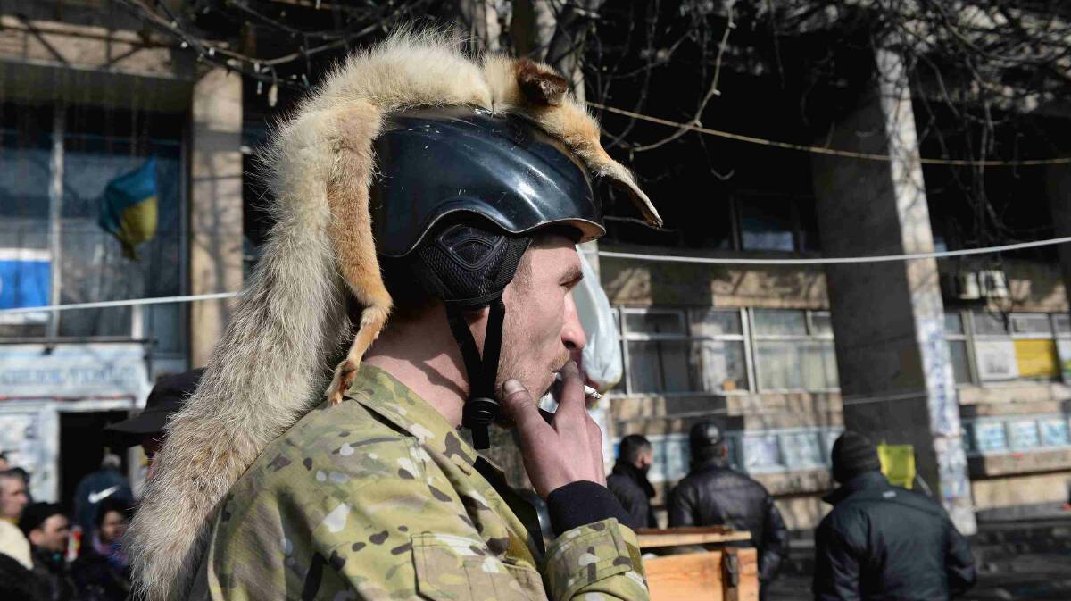A man decorates his helmet with a animal fur as they continue to occupy Independence Square in Kiev. Picture: Getty Images