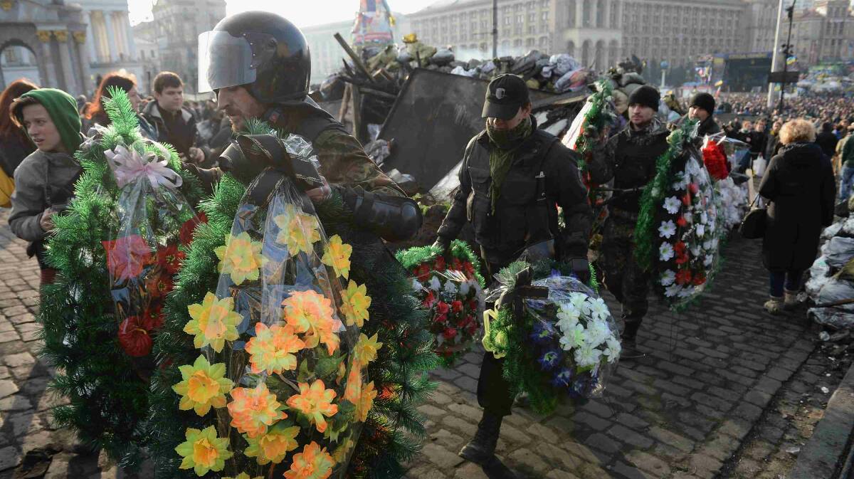 Men carry wreaths for anti-government demonstrators killed in clashes with police in Independence Square in Kiev. Picture: Getty Images