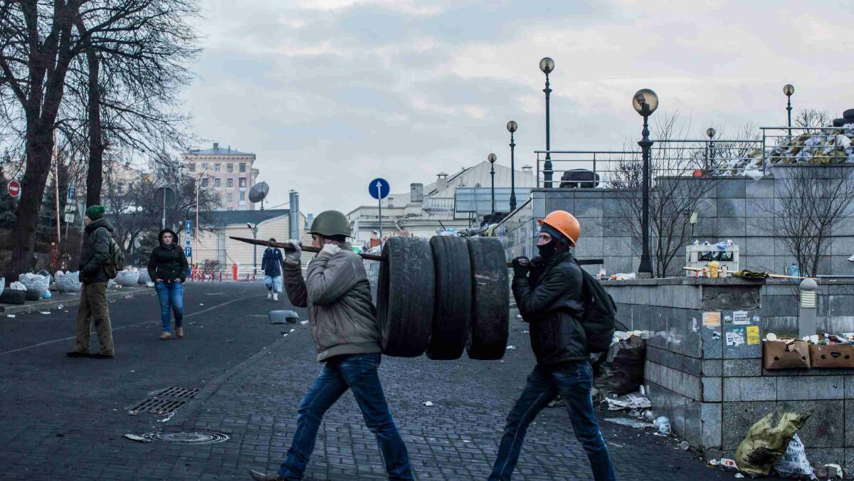 Anti-government protesters carry tires to the barricades in Independence Square in Kiev. Picture: Getty Images