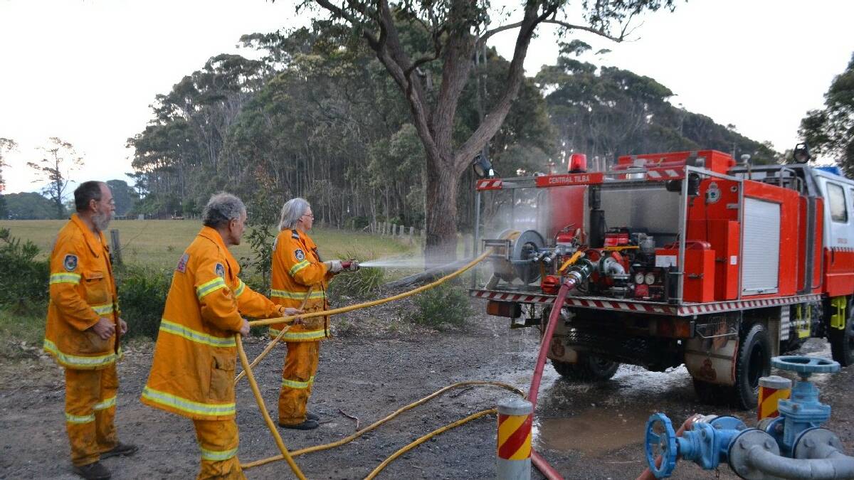 TILBA: Central Tilba RFS brigade firefighters Harry Ghazikian, Dave Alabaster and Tralee Snape hose down   the appliance at Mystery Bay after a tough 12-hour day blacking out.