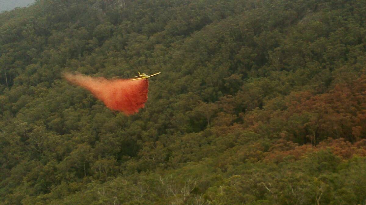 WIRRITIN: A firefighting aircraft bombs the Wirritin fire north-west of Batemans Bay on Monday.
